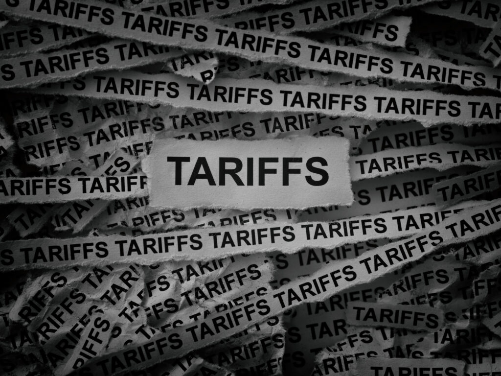 strips of newspaper with the words tariffs typed on them.