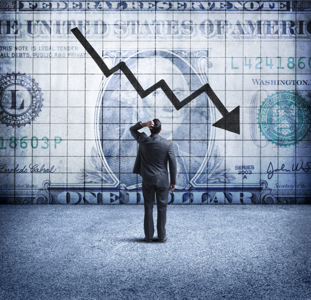 businessman looking up at a chart that indicates a falling u.s. dollar
